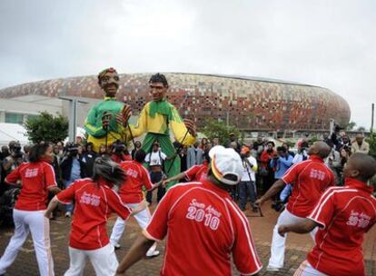 Aficionados surafricanos bailan ayer junto al estadio Soccer City, en Johanesburgo.