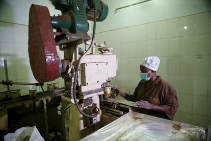 Una mujer trabaja con una máquina de procesamiento del cacao.