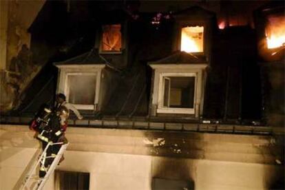 Un bombero rescata a una mujer del hotel siniestrado.