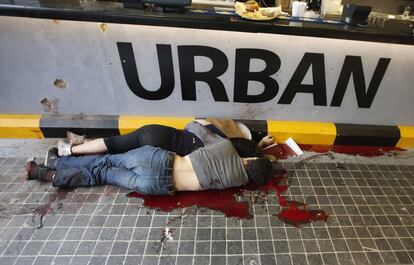 Dos cuerpos sin vida yacen delante de una hamburgueser&iacute;a en el centro comercial. 