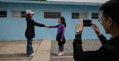 Dos niñas se dan la mano en la réplica de la Zona Desmilitarizada, en Corea del Sur.