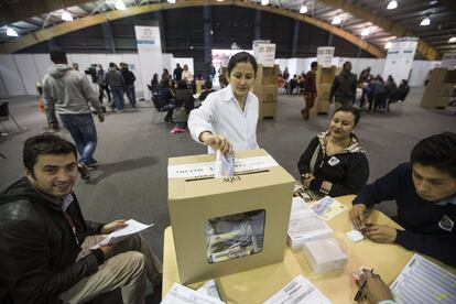 Una dona diposita el seu vot en una urna al centre de convencions de Corferia.