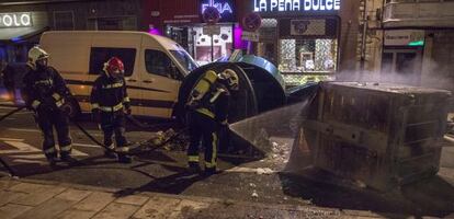 Los bomberos apagan un contenedor incendiado en los incidentes tras la manifestación de Vitoria. 