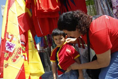 Una madre compra una camiseta con los colores de España a su hijo.