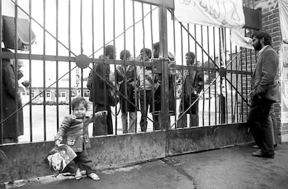 Uma criança com a foto de Khomeini, o então líder supremo iraniano, diante do portão de acesso à Embaixada dos EUA em Teerã, dois dias depois de ter sido remunerada pelos "estudantes revolucionários".