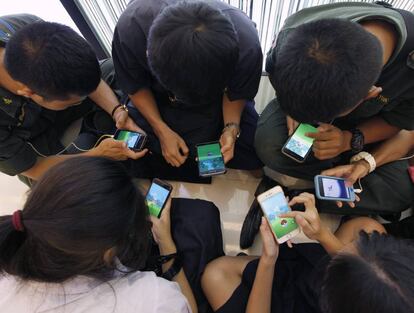 Varios jóvenes juegan a un videojuego desde su teléfono