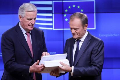 Barnier (izquierda) entrega el borrador del acuerdo a Tusk.