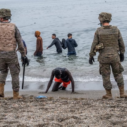 Un hombre yace en la playa mientras el Ejército acordona la zona, este martes.