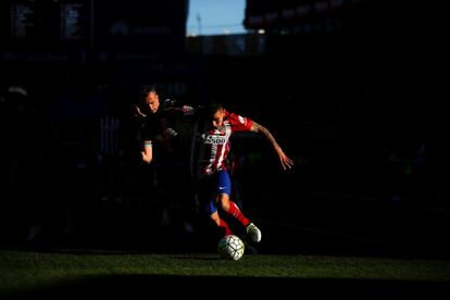 Angel Correa y Antonio Amaya luchan por la pelota durante el Atlético-Rayo. 