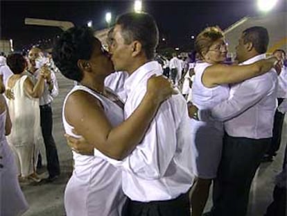 Una pareja brasileña se besa mientras baila samba.
