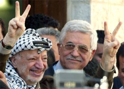 Yasir Arafat hace el signo de la victoria junto a Abu Mazen, a la salida de la votación parlamentaria de ayer.