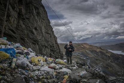 Un minero vuelve a casa caminando por un precipicio inundado por basura compuesta de plástico de un solo uso. La Rinconada, Perú.