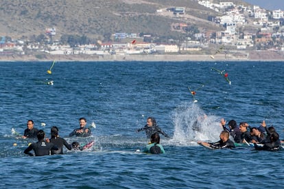 Surfers throw flowers during a tribute to the three victims.