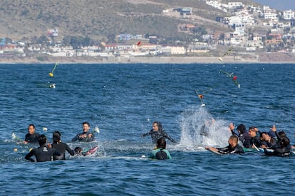 Surfistas lanzan flores durante un tributo a los hermanos Robinson y 
 al americano Rhoad.