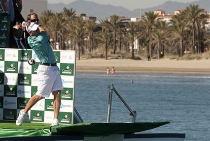El golfista Sergio García golpea una bola desde un barco situado frente a la playa en Castellón.