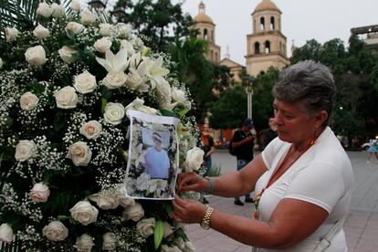 Una mujer deja una foto de Jaime Vásquez, líder social asesinado en Cúcuta, en un arreglo floral en el centro de la ciudad colombiana, abril de 2024. 