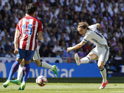 El centrocampista croata del Real Madrid Luka Modric (d) disputa un balón con el defensa montenegrino del Atlético de Madrid Stefan Savic.