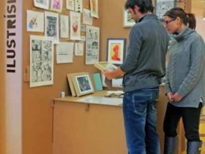 Artistas y visitantes charlan sobre las ilustraciones, que se venden desde 10 euros.