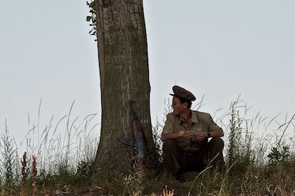 Un soldado norcoreano se toma un descanso cerca de la ciudad de Sinuiju, en frente de la ciudad china de Dandong.
