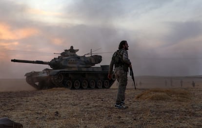Combatientes sirios respaldados por Turquía se reúnen alrededor de un tanque M60 de fabricación estadounidense en las afueras del norte de la ciudad siria de Manbij. Turquía desea crear una "zona de seguridad" de 30 km a lo largo de su frontera para mantener a las fuerzas kurdas a distancia y repatriar una parte de los 3,6 millones de refugiados sirios que están en su territorio.