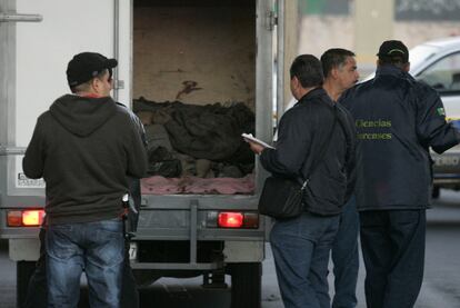 Miembros del equipo forense, junto a una de las camionetas donde fueron hallados los cadáveres, ayer en Guadalajara.