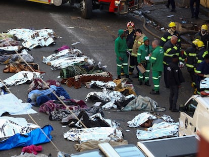 Personal de rescate y bomberos junto a los cuerpos de las víctimas del incendio en el centro de Johannesburgo, este jueves.
