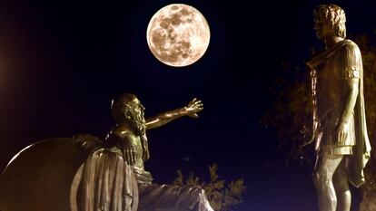 La 'superluna de nieve' se alza entre las estatuas de Alejandro Magno (a la derecha) y Diógenes de Sínope, en Corinto (Grecia).