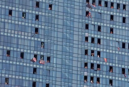 Aficionados del equipo rojiblanco animan al equipo desde las ventanas de un edificio de apartamentos.