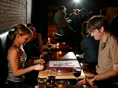 A couple plays Scrabble while sipping wine in a Los Angeles bar.