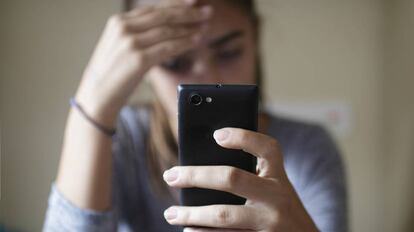 Una mujer observa su móvil, uno de los dispositivos afectados por los fallos en los procesadores.
