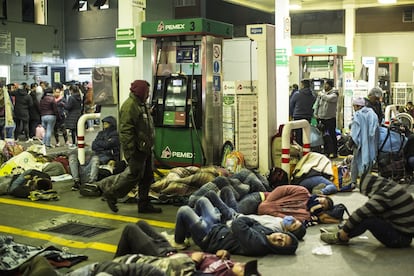 Un grupo de personas duerme en una gasolinera. Los visitantes acampan en diferentes espacios en las zonas próximas al recinto religioso.