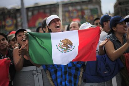 Una mujer ondea una bandera mexicana durante los actos de la plaza del Zócalo.