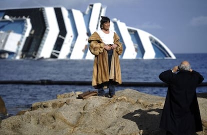 Una mujer posa frente al casco del 'Costa Concordia', que naufragó frente a la isla de Giglio el 13 de enero.