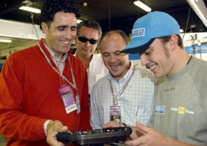 Fernando Alonso explica el mecanismo de su volante a Miguel Indurain, ayer, en Montmel.