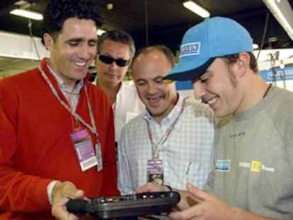 Fernando Alonso explica el mecanismo de su volante a Miguel Indurain, ayer, en Montmeló.