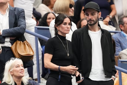 Courtney Cox y Johnny McDaid esperan el inicio del partido entre Carlos Alcaraz y Jannik Sinner.