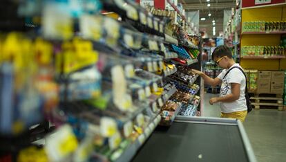 Menino na seção de doces de um supermercado.