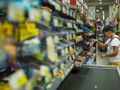 Menino na seção de doces de um supermercado.