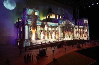 Un vídeo de animación de fuego y humo se proyecta en una maqueta del edificio del Reichstag como representación del fuego que se declaró allí el 27 de febrero de 1933, en Berlín (Alemania).