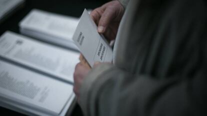 Un elector escoge entre las papeletas de los diferentes partidos en un colegio de Barcelona.