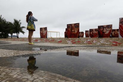 Una mujer mira una instalación a manera de manifestación organizada por la ONG Río de Paz en la playa de Copacabana.