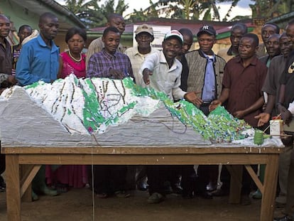 El maestro pigmeo Irangi (en el centro) muestra un mapa tridimensional de su zona en la Reserva de Itombwe, en RDC.