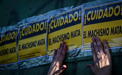 Una mujer pega carteles contra el machismo durante una manifestación por el Día Internacional para la Eliminación de la Violencia contra la Mujer en noviembre de 2023 en Santiago de Chile.