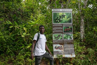 Un joven guía con el Fondo Mundial para la Naturaleza (WWF, sus siglas en inglés) es retratado frente a un letrero que informa de las especies de anfibios y serpientes que pueden avistarse en el sendero ecológico entre Capurganá y Sapzurro.