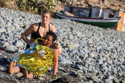 Una bañista en la playa del Águila, en Gran Canaria, ayuda a una inmigrante que llegó en una patera, en 2019.
