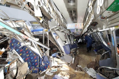 Un trabajador examina uno de los vagones destrozados del tren que descarriló en Amagasaki, al oeste de Japón.