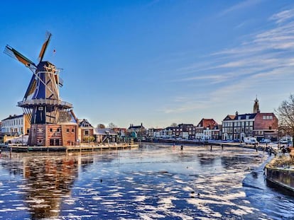 Estampa invernal del río Spaarne, con el molino De Adriaan, en Haarlem (Países Bajos).