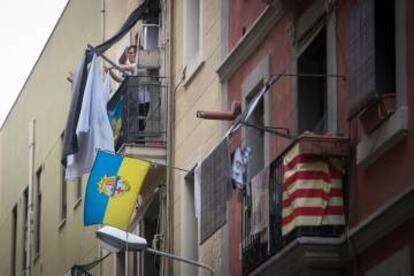 Una mujer tiende la ropa en el balcón de su casa de la Barceloneta.