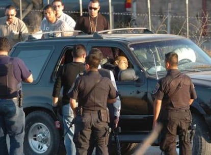 Miembros de la Policía observan el vehículo en el que fueron asesinados este 23 de octubre de 2008, los oficiales Juan Francisco Gómez y Arturo Granillo Córdoba, en Rosarito, estado de Baja California (México). Tres civiles más, entre ellos una mujer, fueron asesinados este jueves cuando viajaban en su automóvil en la misma zona.