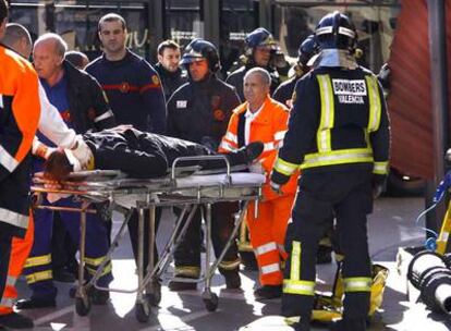 Un hombre herido por el desprendimiento de un tejado metálico en la calle de la Paz de Valencia es trasladado a una ambulancia.
Un coche aplastado por un árbol derribado por el viento en la calle del Rey Saúd de Valencia.